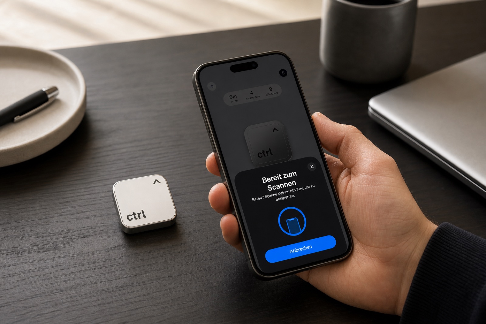 A hand scanning the ctrl key with an iPhone at a desk